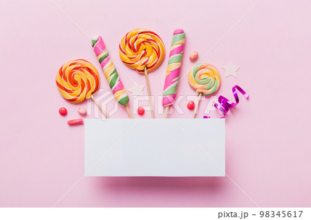 Flat lay holiday composition. Paper blank, lollipop, birthday decorations on Colored background. Top view, copy space for text Flat lay holiday composition. Paper blank, lollipop, birthday decorations on Colored background. Top view, copy space for text 98345617