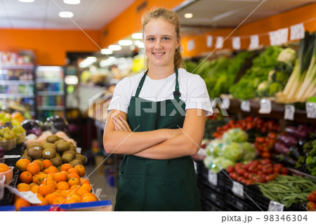 Pretty young saleswoman posing at grocery 98346304