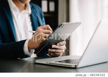businessman hand using smart phone, tablet payments online shopping, omni channel, digital tablet docking keyboard computer at office . businessman hand using smart phone, tablet payments online shopping, omni channel, digital tablet docking keyboard computer at office . 98346592