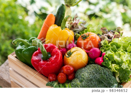 Wooden crate filled with fresh organic vegetables . 98346652