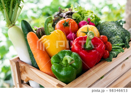 Wooden crate filled with fresh organic vegetables . 98346653