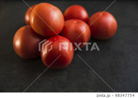 red tomatoes on a dark kitchen counter 98347754