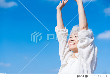 外で伸びをするシニアの女性 98347904