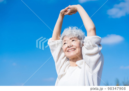 外で伸びをするシニアの女性 98347908