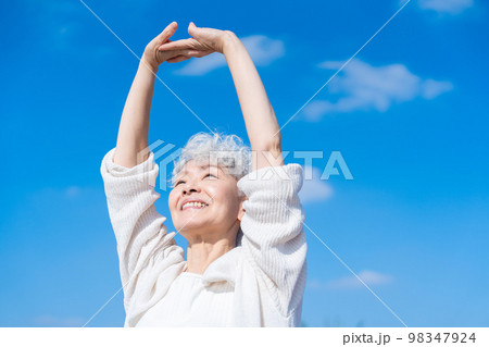 外で伸びをするシニアの女性 外で伸びをするシニアの女性 98347924
