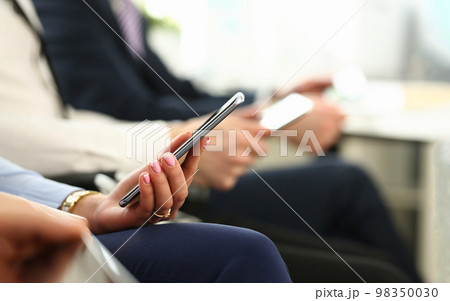 Closeup of business people hands are holding smartphone Closeup of business people hands are holding smartphone 98350030