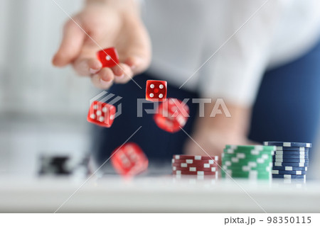 Player rolls dice on poker table closeup 98350115