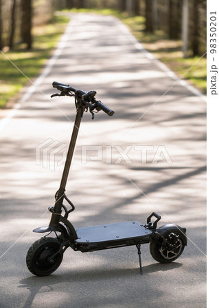Black Electric scooter standing on the running board on the street Black Electric scooter standing on the running board on the street 98350201