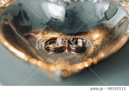 Designer wedding rings lying on the surface. Two wedding rings Designer wedding rings lying on the surface. Two wedding rings 98350512