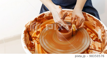 Master making a pot on pottery wheel, top view,banner Master making a pot on pottery wheel, top view,banner 98350576