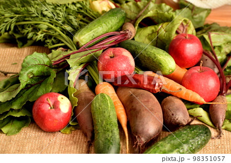 The harvest of vegetables and fruits lies on burlap. 98351057