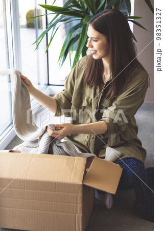 Woman is posing with a coral bag with a pink silk scarf on the wall  background outdoors. She wears a white pantsuit. Closeup vertical photo  Stock Photo - Alamy