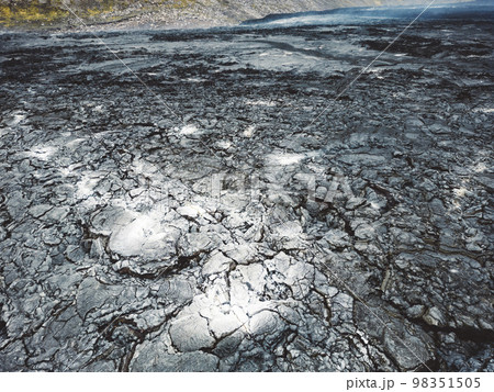 Aerial view of cooled down lava rocks with ash grey spots on the surface in the valley near Geldingadalir volcano 98351505
