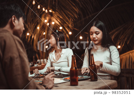 young people eating steak enjoying with friends in the party young people eating steak enjoying with friends in the party 98352051