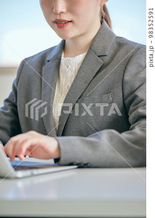 オフィスでパソコンをタイピングする若い女性 98352591