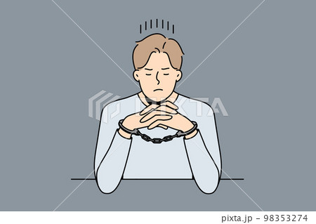 Unhappy man in handcuffs sit at table Unhappy man in handcuffs sit at table 98353274