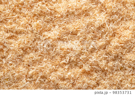 Wood flour, wood powder, surface of fine sawdust, formed by sawing dried spruce. Finely pulverized wood, a by-product and waste product, mainly used as a filler and extender. From above, macro photo. Wood flour, wood powder, surface of fine sawdust, formed by sawing dried spruce. Finely pulverized wood, a by-product and waste product, mainly used as a filler and extender. From above, macro photo. 98353731