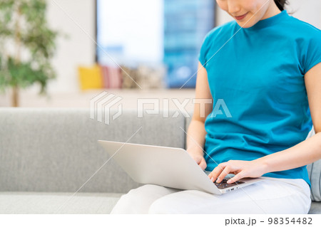 ソファーでノートPCを操作する若い女性（パーツ） 98354482