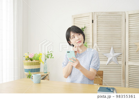 家でスマホ持って考える女性 家でスマホ持って考える女性 98355361