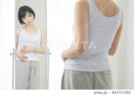 鏡を見て体型に悩む女性 98355390