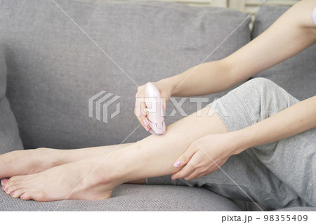 家で足のセルフ脱毛をする女性　顔無し 98355409