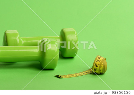 Barbells made of plastic by long soft ruler. Sports equipment Barbells made of plastic by long soft ruler. Sports equipment 98356156