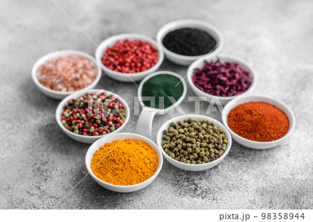 Composition consisting of a variation of several types of spices in white ceramic bowls 98358944