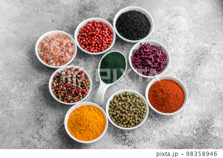 Composition consisting of a variation of several types of spices in white ceramic bowls Composition consisting of a variation of several types of spices in white ceramic bowls 98358946