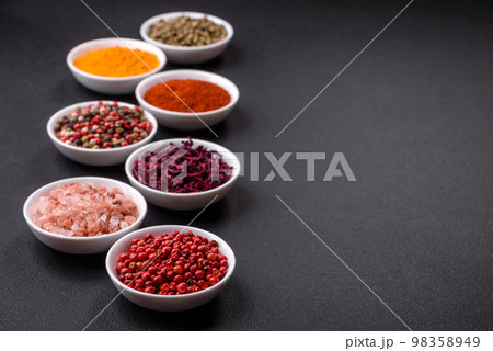 Composition consisting of a variation of several types of spices in white ceramic bowls Composition consisting of a variation of several types of spices in white ceramic bowls 98358949