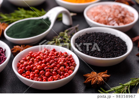 Composition consisting of a variation of several types of spices in white ceramic bowls 98358967