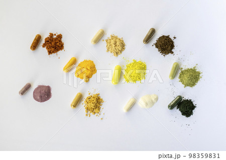 Opened and whole capsules of supplements on white background. Various pills and vitamins. From top right to left as follows: curcumin, vitamin C, ant tree bark, quercetin, q10, vegetable supplement 98359831