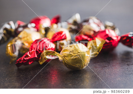 Sweet candy wrapped in foil on kitchen table. 98360289