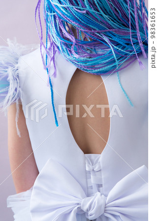 Rear view. Beautiful girl in an evening dress. Elegant dress with a neckline. The sleeves are decorated with feathers. Elegant big bow. Long multi-colored braids. Young beauty Rear view. Beautiful girl in an evening dress. Elegant dress with a neckline. The sleeves are decorated with feathers. Elegant big bow. Long multi-colored braids. Young beauty 98361653