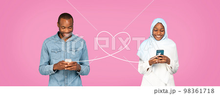 Black Man With Smartphone Sending Love Message To Muslim Woman In Hijab Black Man With Smartphone Sending Love Message To Muslim Woman In Hijab 98361718
