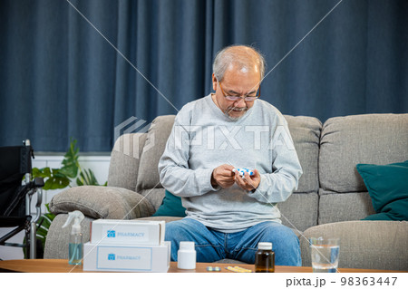 Asian old man buy herbal self cure Rx pill online from pharmacy, worried senior man with medicine pills he read on see how to take pills before taking, home isolation, Medical service concept Asian old man buy herbal self cure Rx pill online from pharmacy, worried senior man with medicine pills he read on see how to take pills before taking, home isolation, Medical service concept 98363447