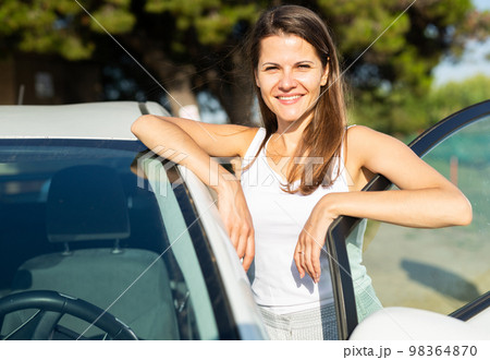 Portrait of driver caucasian woman next to car Portrait of driver caucasian woman next to car 98364870