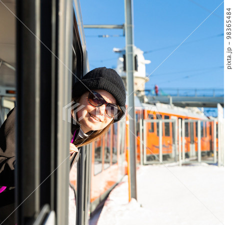 Woman poking her head out of train window during trip Woman poking her head out of train window during trip 98365484