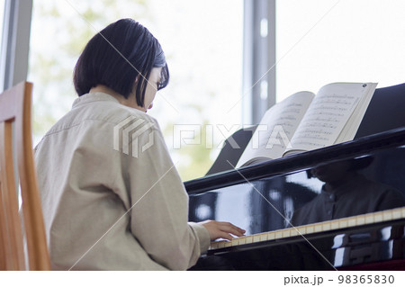 ピアノの楽譜をめくる若い日本人女子学生 ピアノの楽譜をめくる若い日本人女子学生 98365830