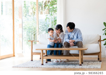 リビングでスマホを見る若い家族 リビングでスマホを見る若い家族 98366265