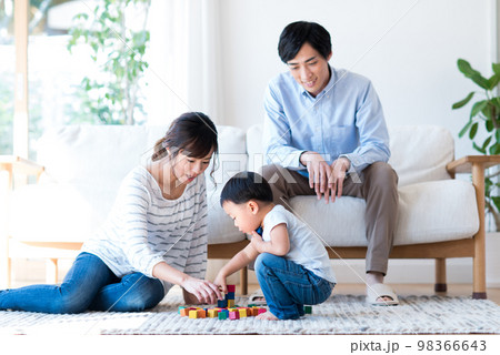 リビングでくつろぐ若い家族 98366643