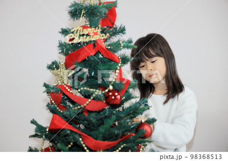 クリスマスツリーを飾り付ける女子小学生 (8歳) クリスマスツリーを飾り付ける女子小学生 (8歳) 98368513