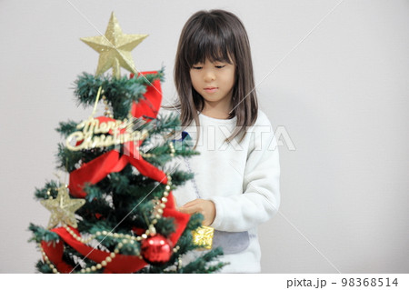 クリスマスツリーを飾り付ける女子小学生 (8歳) クリスマスツリーを飾り付ける女子小学生 (8歳) 98368514
