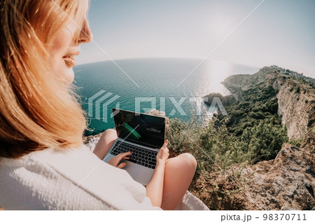 Woman sea laptop. Business woman working on laptop by sea at sunset. Close up on hands of pretty lady typing on computer outdoors summer day. Freelance, digital nomad, travel and holidays concept. 98370711