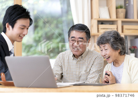 訪問営業と話しをするシニア夫婦 98371746