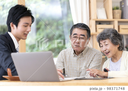 訪問営業と話しをするシニア夫婦 98371748