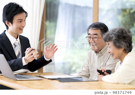 訪問営業と話しをするシニア夫婦 98371749