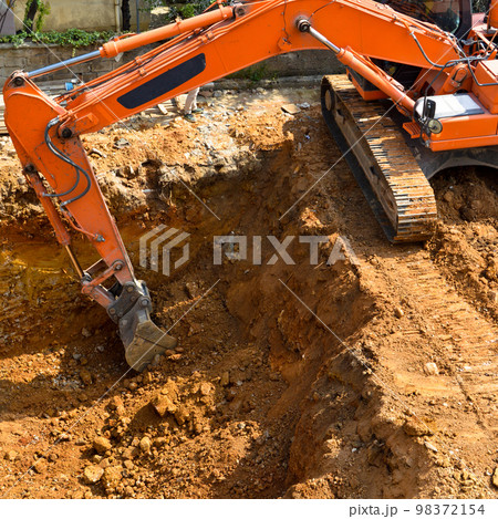 Excavator continues to work at the construction site 98372154