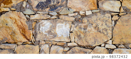 Sturdy yellow and beige cut stone wall, seamless lined up 98372432