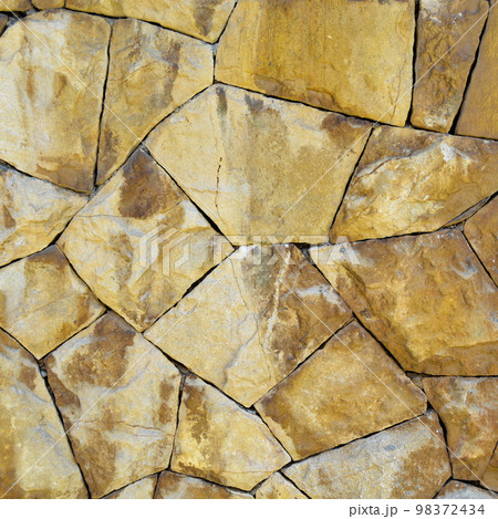 Sturdy yellow and beige cut stone wall, seamless lined up 98372434