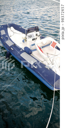 Modern inflatable boat with engine in the sea near shore 98372657